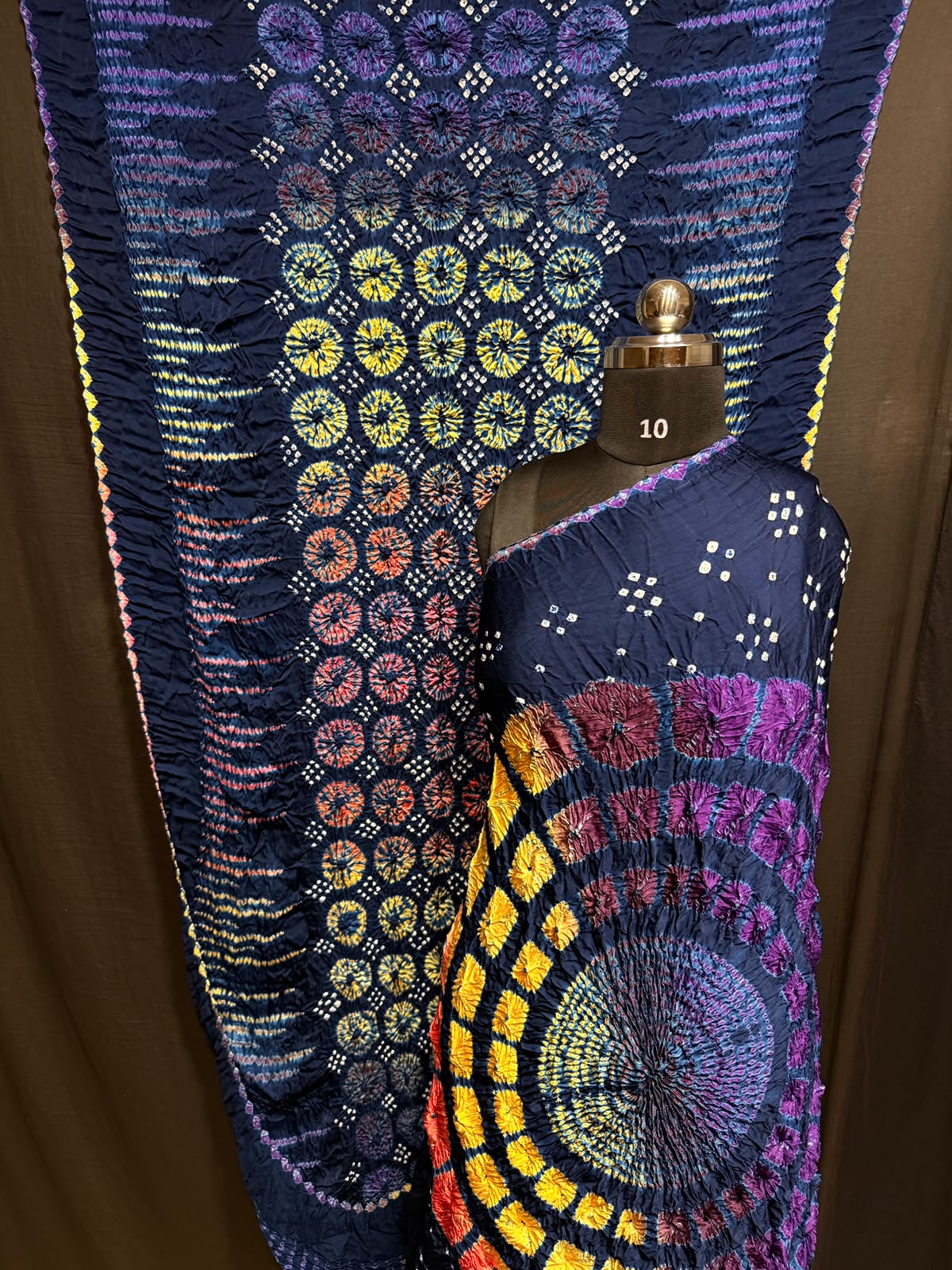 ## Sibori with Bandhej Saree ##
**Fabric**: Modal Silk
- Multi Sibori design
- Handcrafted item
**Description**:
- **Length**: 6.50 meters
- **Width**: 44-46 inches
- **Wash Care**: Dry clean only