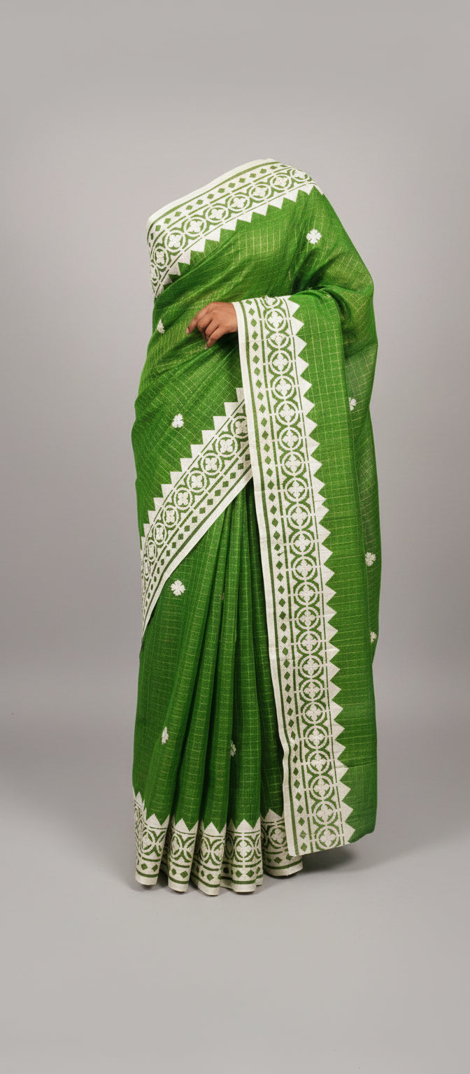 Green saree with white patterns on a wooden background