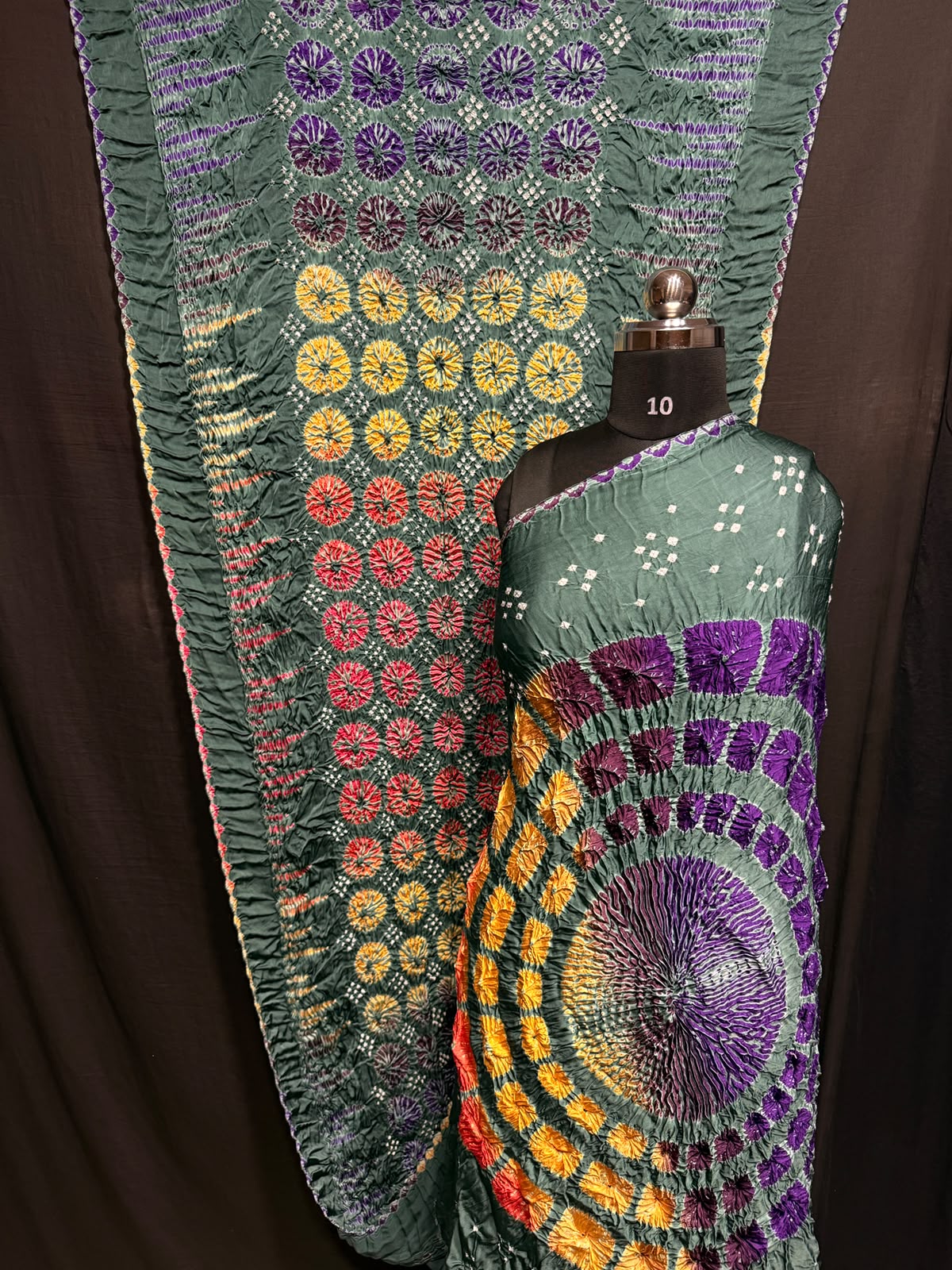 ## Sibori with Bandhej Saree ##
**Fabric**: Modal Silk
- Multi Sibori design
- Handcrafted item
**Description**:
- **Length**: 6.50 meters
- **Width**: 44-46 inches
- **Wash Care**: Dry clean only